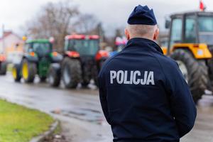 fot. kwp Rzeszów protest rolników, widać policjanta odwróconego tyłem w tle pojazdy wolnobieżne