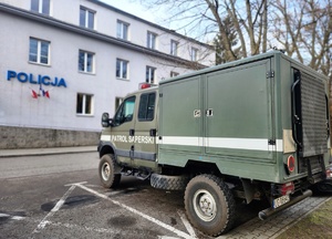 patrol minerski-samochód na tle mieleckiej komendy Policji