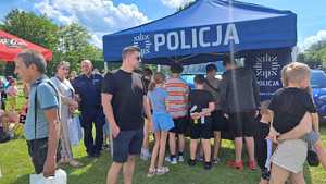 mieleccy policjanci z dziećmi i ich opiekunami uczestniczącymi w imprezie plenerowej Dzień Dziecka na Błoniach MOSiR w Mielcu