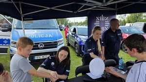 mieleccy policjanci z dziećmi i ich opiekunami uczestniczącymi w imprezie plenerowej Dzień Dziecka na Błoniach MOSiR w Mielcu