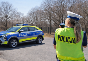 policjantka dokonująca pomiaru prędkości przy radiowozie