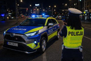 policjantka przy radiowozie mierzy prędkość